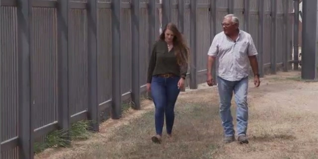 Debra Bell and Norman Esquivel walking by the southern border