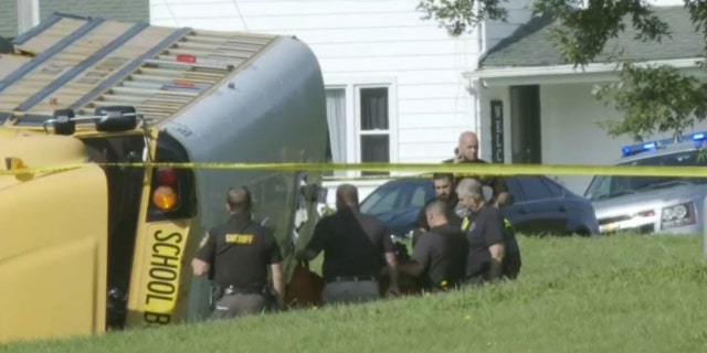 overturned school bus and investigators
