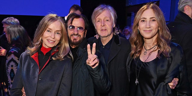 Barbara Bach and Ringo Starr with a peace sign stand next to Paul McCartney and Nancy Shevell 