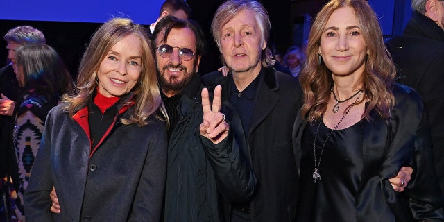 Barbara Bach and Ringo Starr with a peace sign stand next to Paul McCartney and Nancy Shevell 