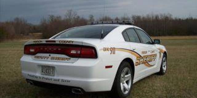 white sheriff's patrol car in field