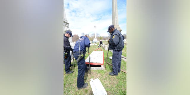 Investigators search the crypt where they found two bodies