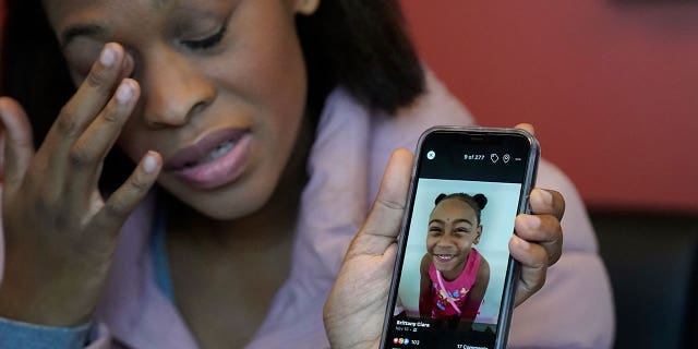 Brittany Tichenor-Cox holds a photo of her daughter