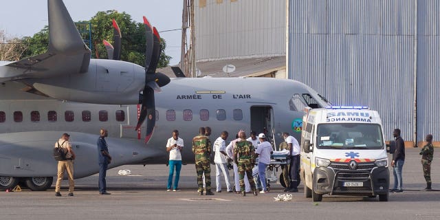 airport personnel transfer migrant survivor into ambulance