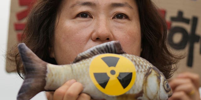 woman holds fish toy