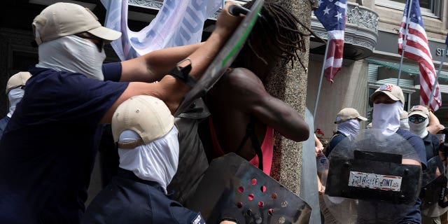 members of Patriot Front shove Black man with shields