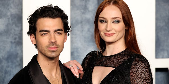 Joe Jonas in black and Sophie Turner in a sparkly lace black dress on the carpet at the Vanity Fair Oscar party
