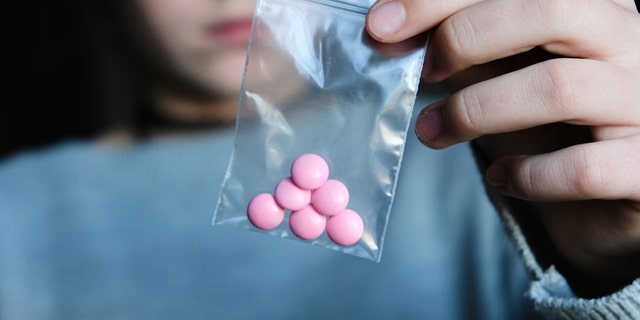 Teen holding pills