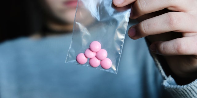 Teen holding pills