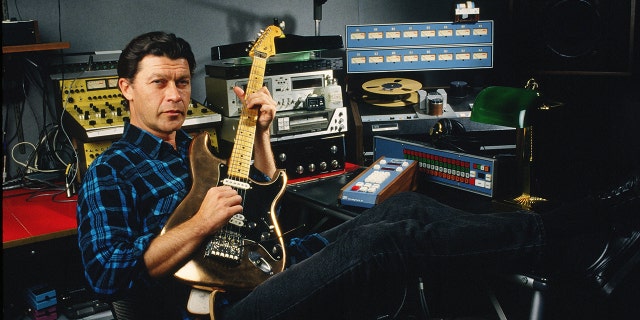 Robbie Robertson holds guitar in recording studio