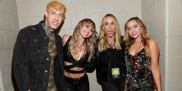 Trace, Miley and Brandi Cyrus pose with their mother Tish at the iHeartRadio Music Festival with Tish making a silly face