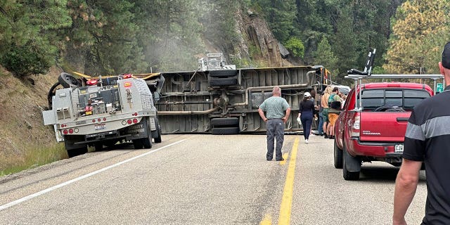 People checking the scene of an overturned school bus