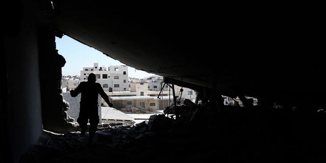 Palestinian engineer inspects a demolished home