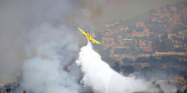 aircraft drops water over fire