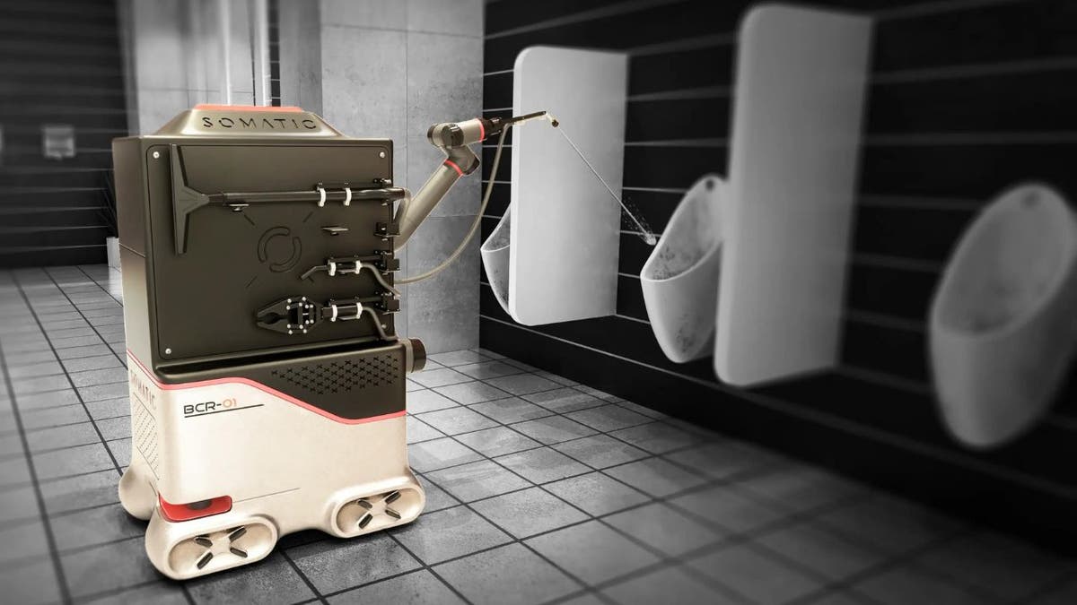 A Somatic AI robot shown in color is cleaning a toilet in a black and white restroom