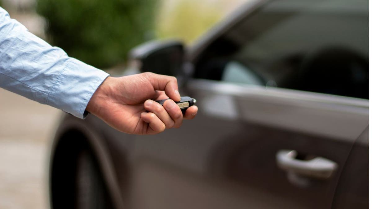 Person's hand holding keys to lock car