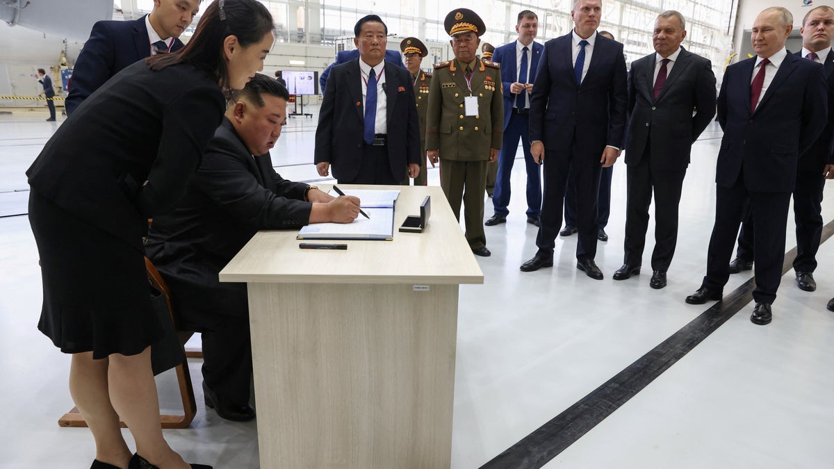 North Korean leader Kim Jong Un signs the visitors book next to his sister, Kim Yo Jong, during their visit to the Vostochny Сosmodrome to meet with Russian President Vladimir Putin on Sept. 13, 2023.
