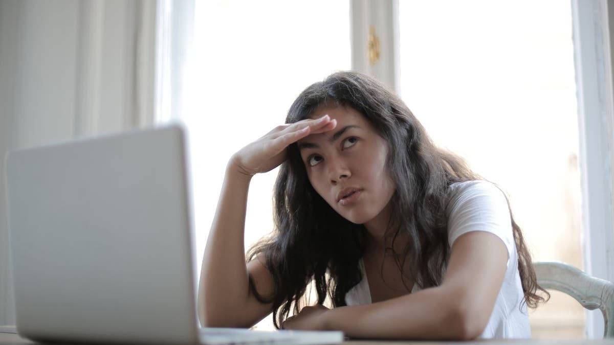 Woman sitting at her computer with an upset look.