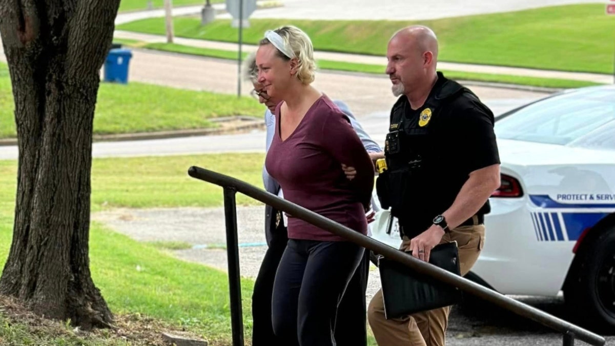 Police escort Alissa McCommon up an outdoor staircase
