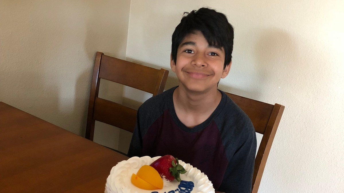 Diego Stolz poses in front of a birthday cake