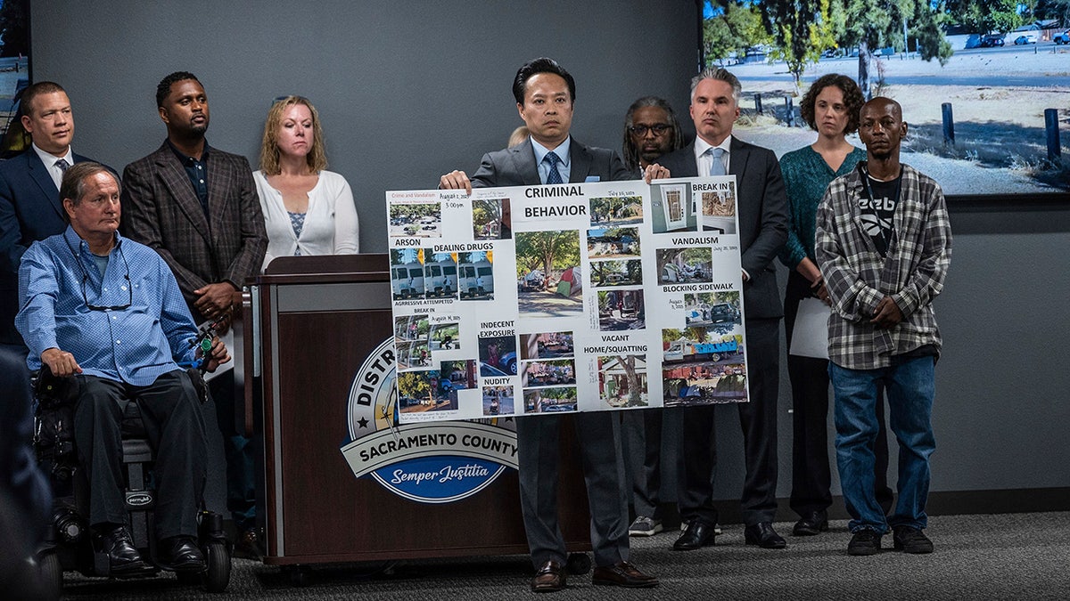 Sacramento DA Thien Ho at press conference displays placard of homeless crime