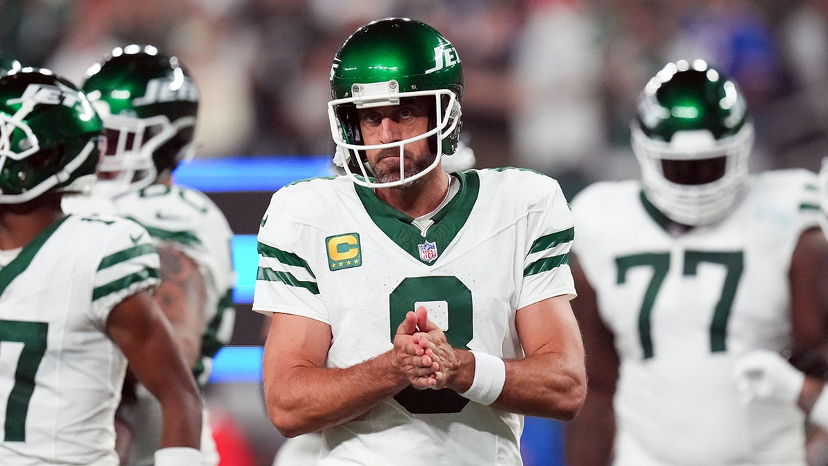 New York Jets' Aaron Rodgers huddles