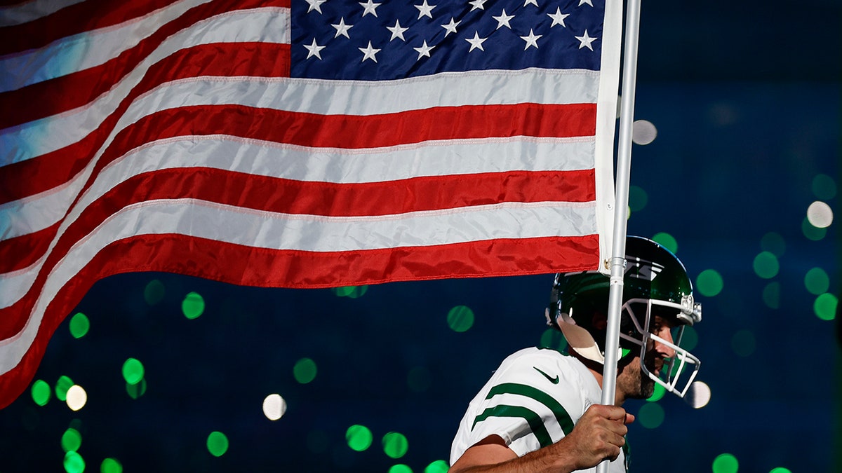 Aaron Rodgers carries the American flag