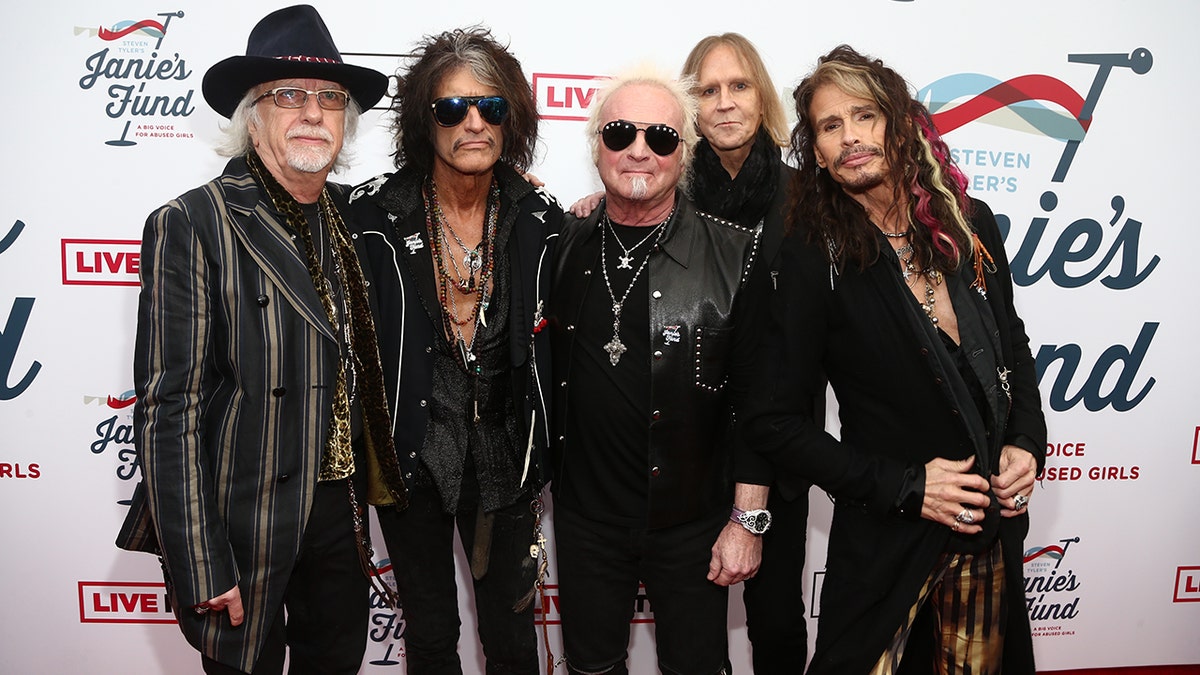 Brad Whitford, Joe Perry, Joey Kramer, Tom Hamilton and Steven Tyler pose together on the red carpet