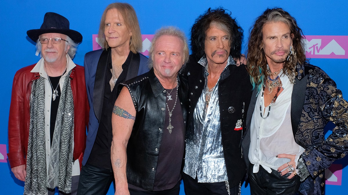 Aerosmith posing together on the red carpet