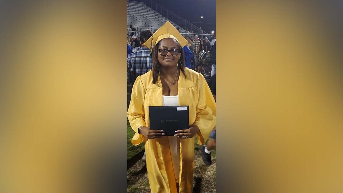 Amiya Harmon in yellow graduation cap and gown