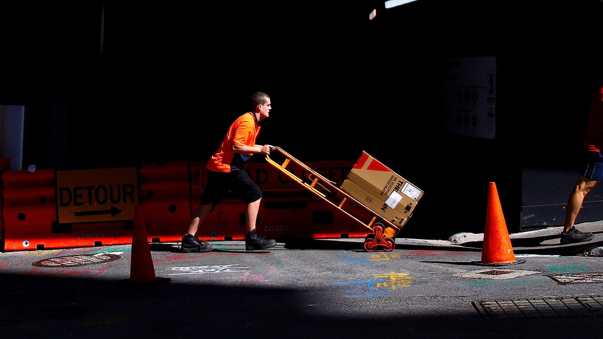 Woker pushes trolley of goods