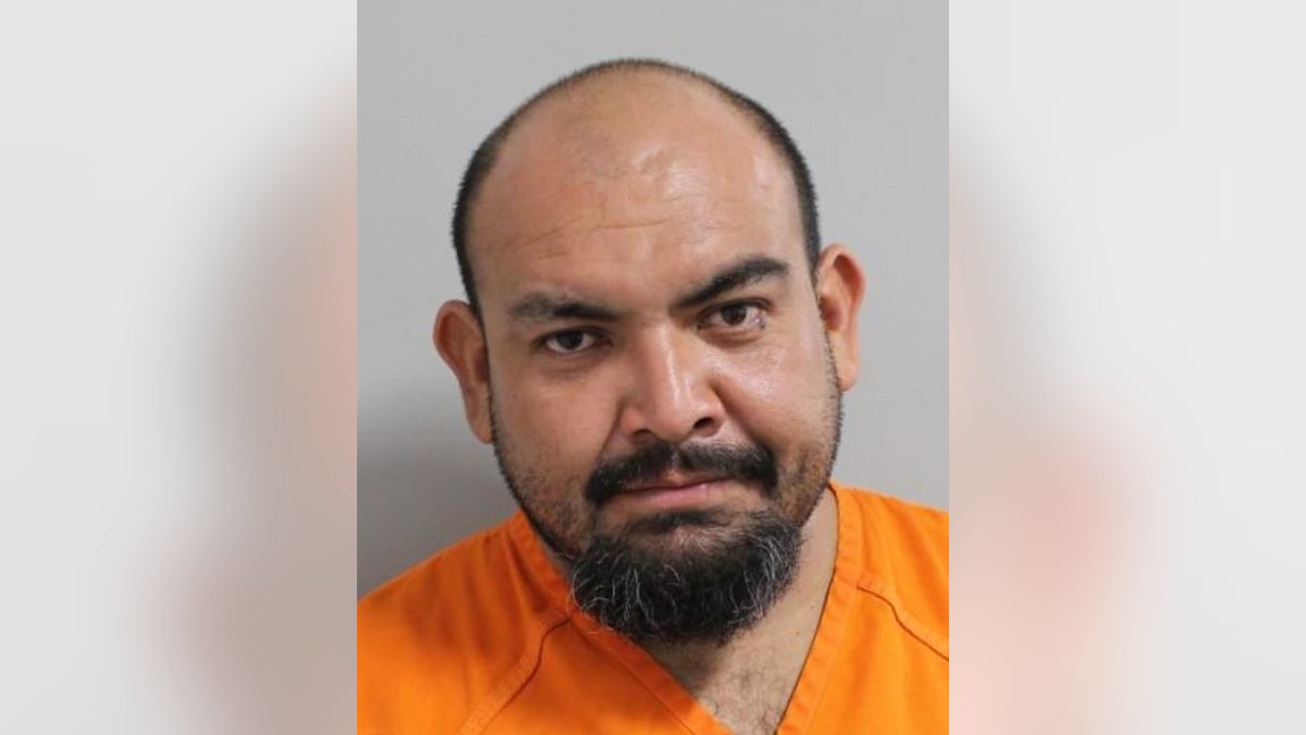 Jose Chaidez, wearing an orange jail top, has his mugshot taken