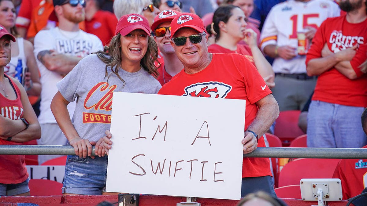 Taylor Swift fans hold a sign