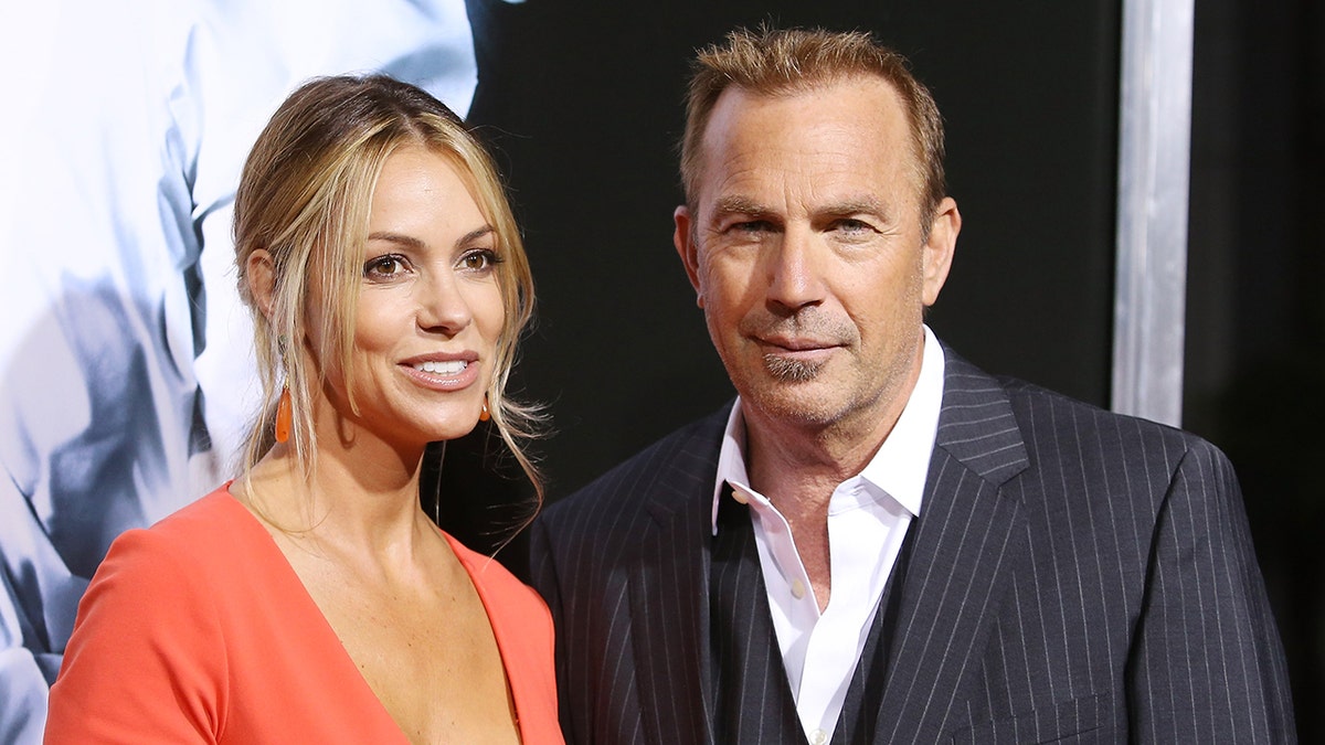 Christine Baumgartner y Kevin Costner sonriendo para una foto