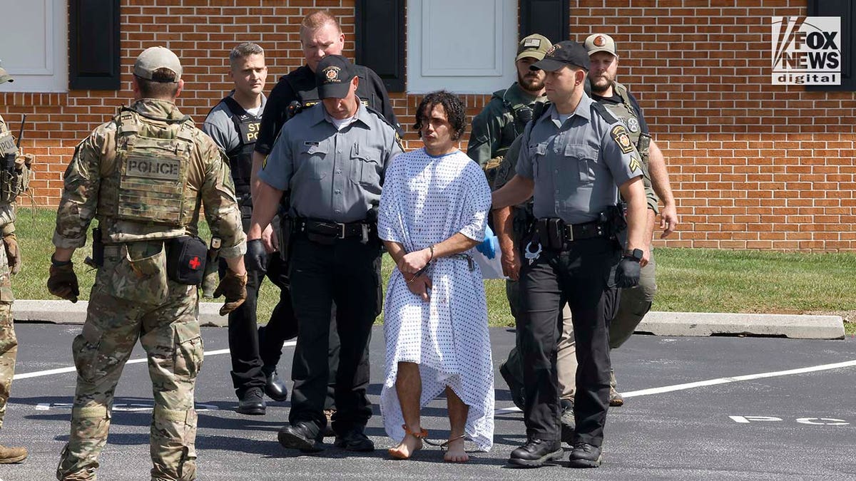 Danelo Cavalcante is escorted out of the Pennsylvania Police Headquarters