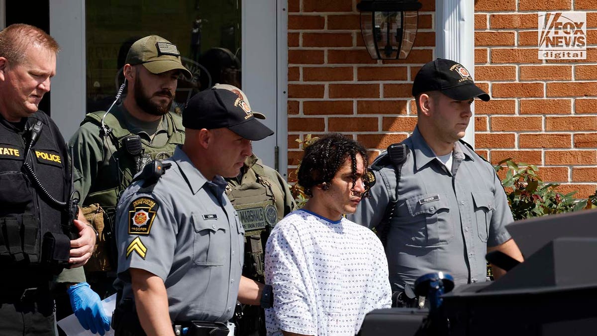 Danelo Cavalcante is escorted out of the Pennsylvania Police Headquarters