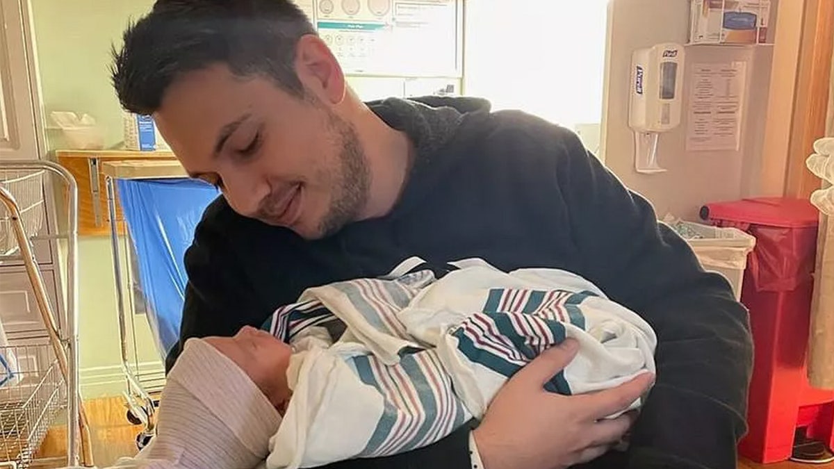 Jared Wilson holds newborn baby.