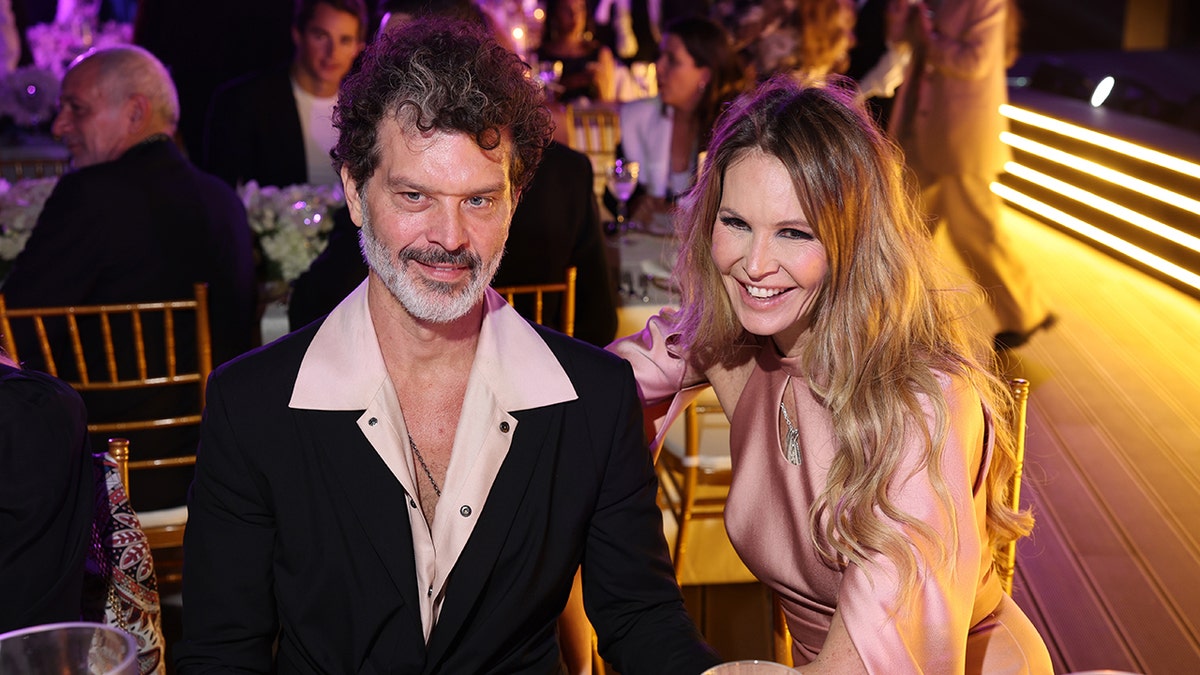 Doyle Bramhall II and Elle Macpherson sit together