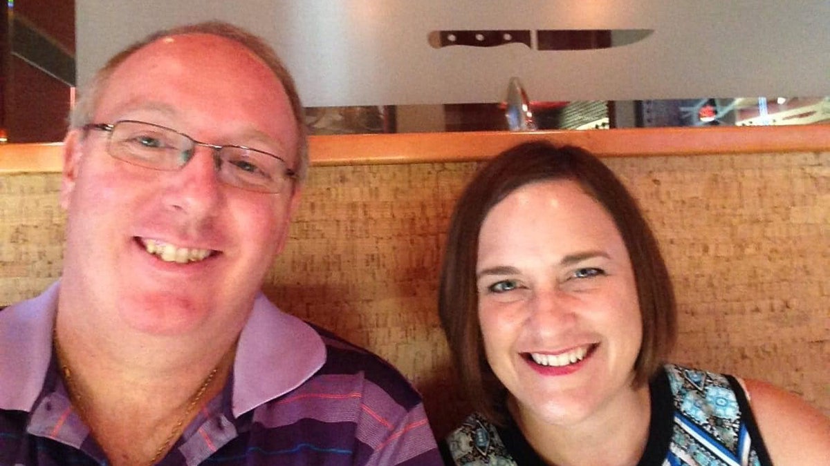 Robbie and Jennifer smile at a restuarant