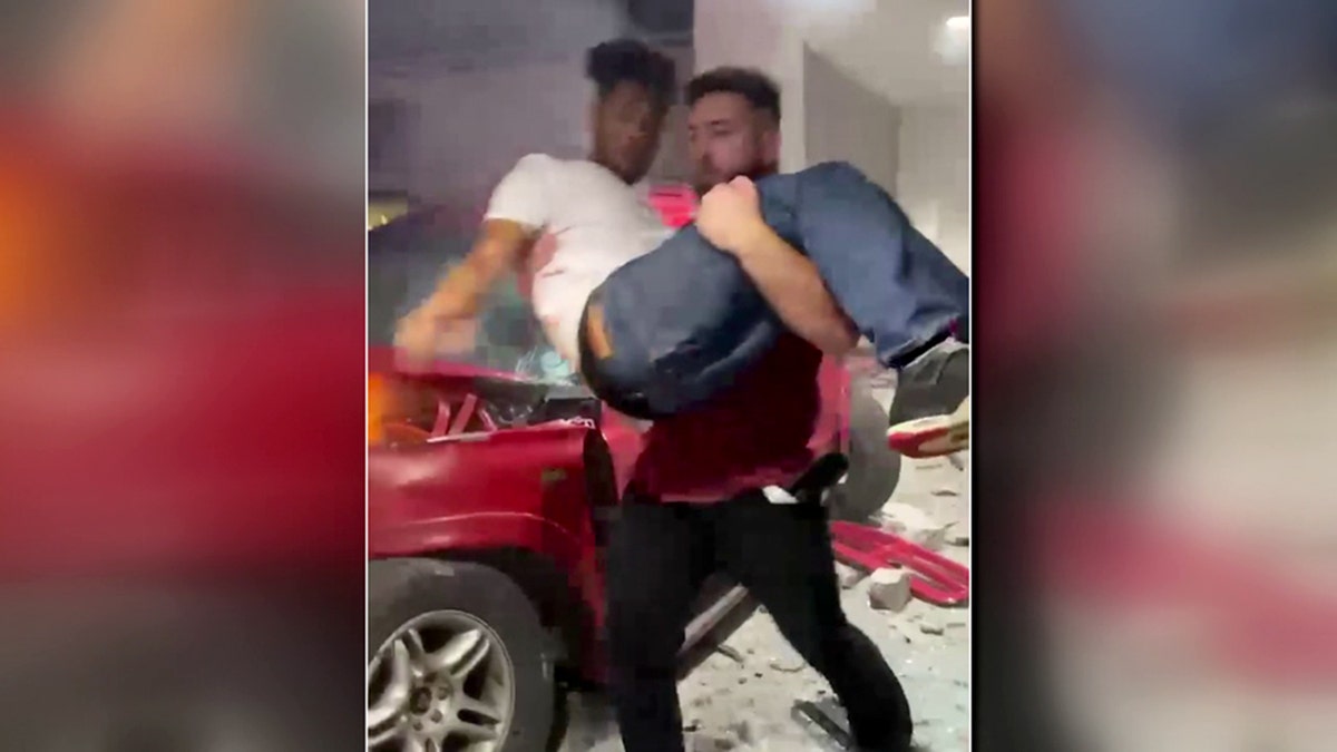 Freeze frame shows good Samaritan pulling man from burning car