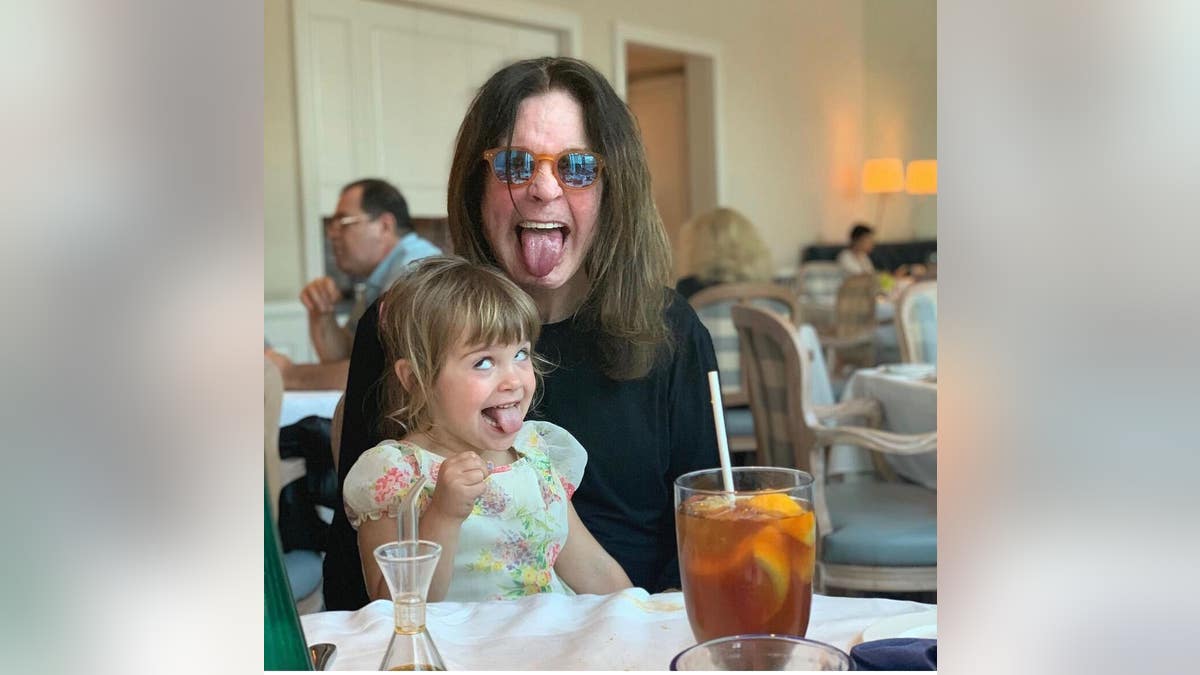 ozzy osbourne holding granddaughter and sticking tongue out
