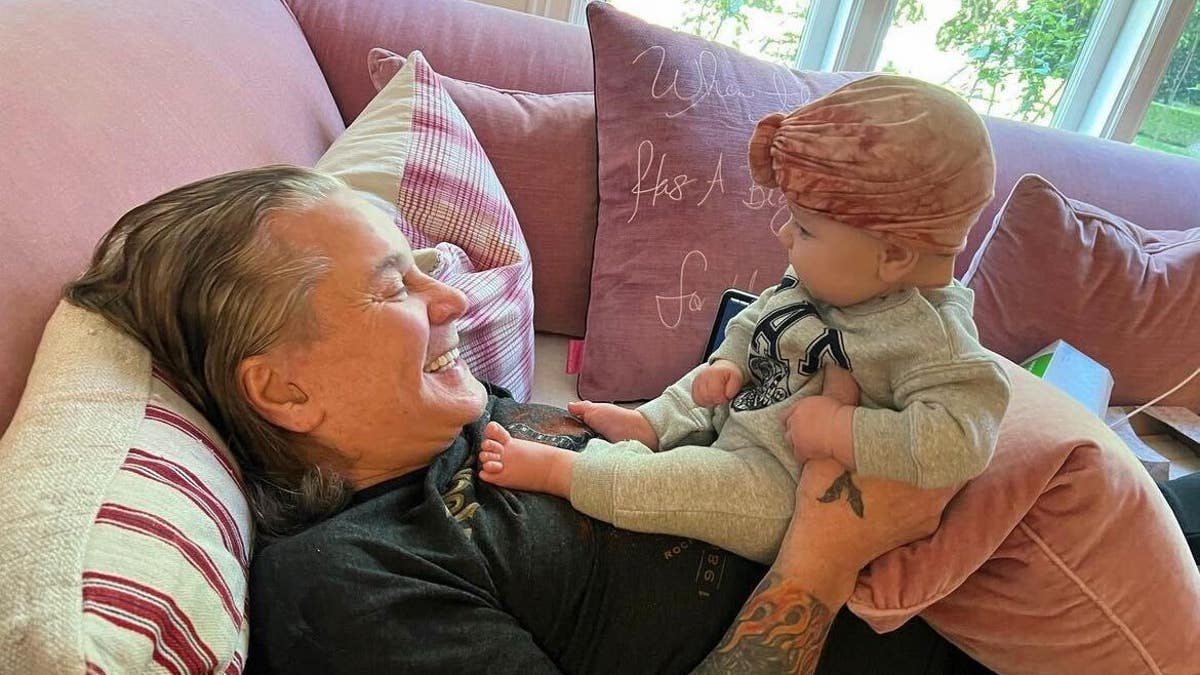 ozzy osbourne holding baby granddaughter on his chest