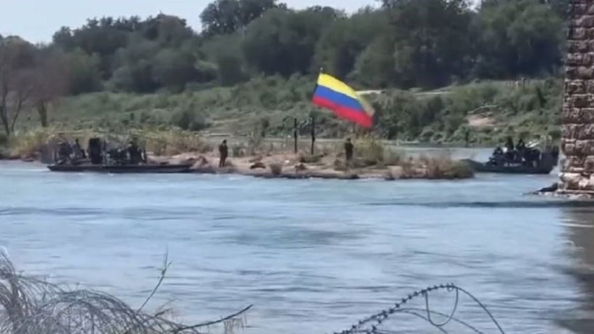 Texas DPS marine troopers go to take down what appears to be a Colombian flag down from an island off Eagle Pass, Texas erected by migrants
