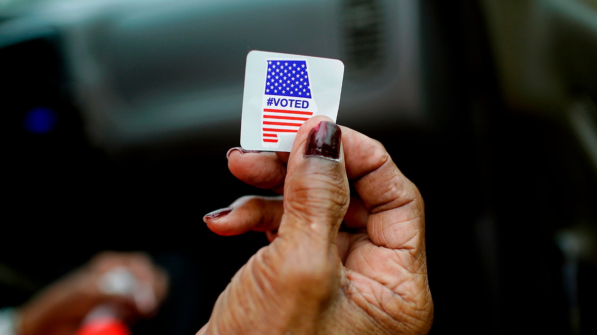 A hand holding a voting sticker