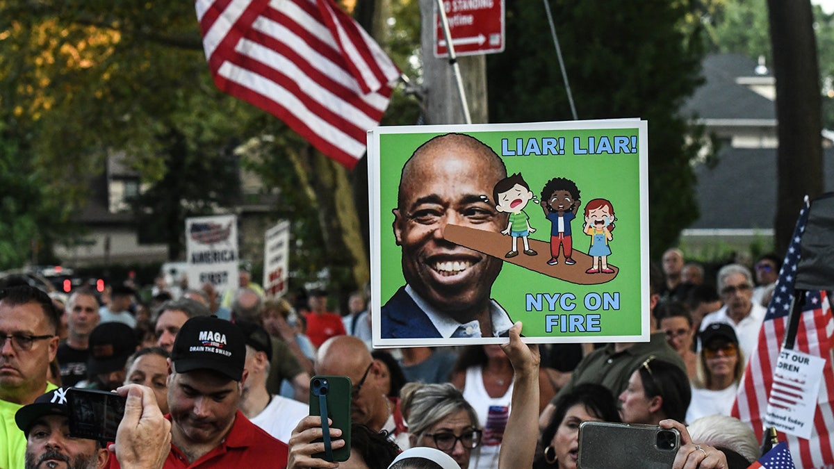 Eric Adams cartoon poster during State Island migrant protest