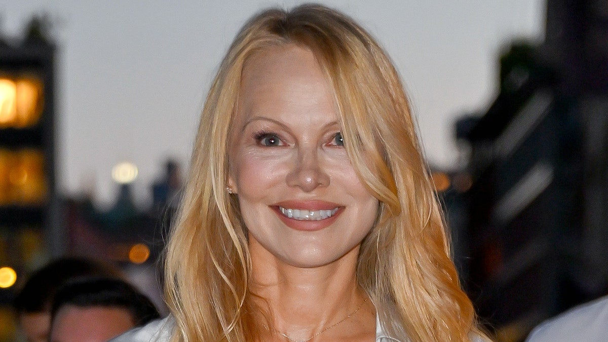 Pamela Anderson smiles in a stain blouse in the streets of New York