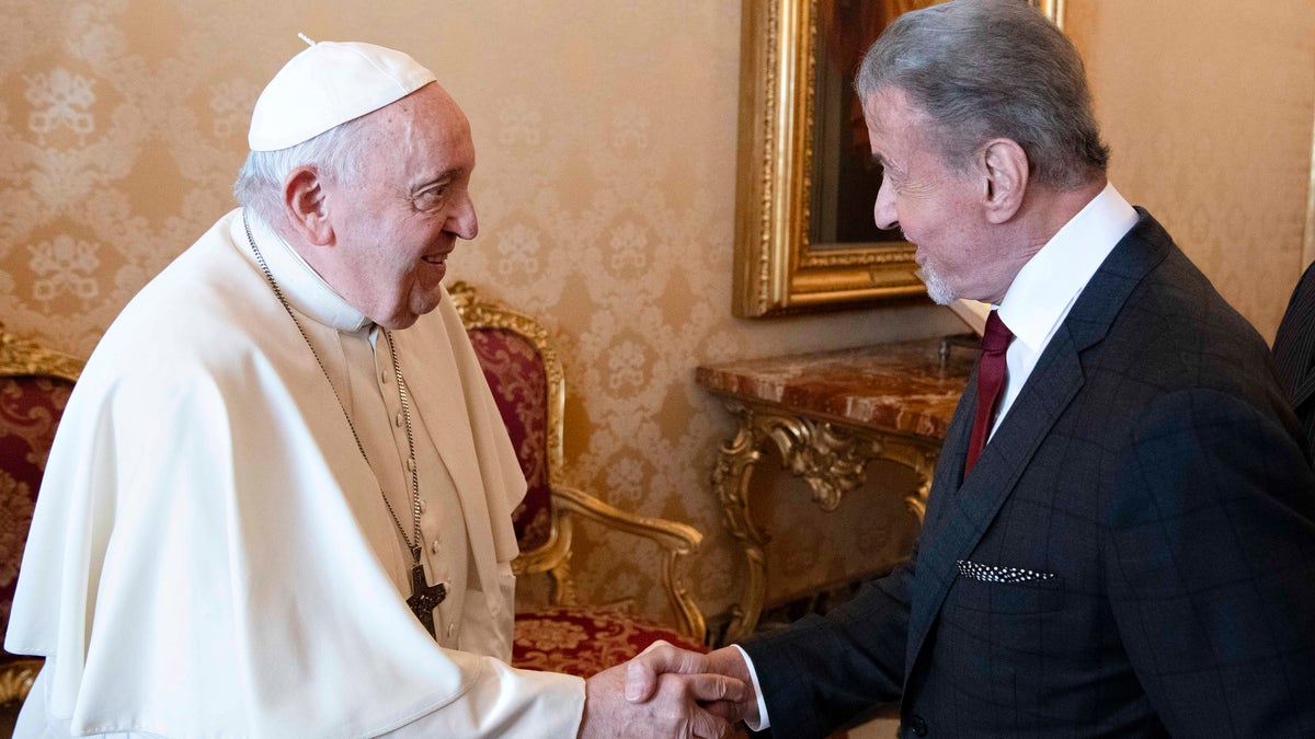 Pope Francis and Sylvester Stallone shake hands