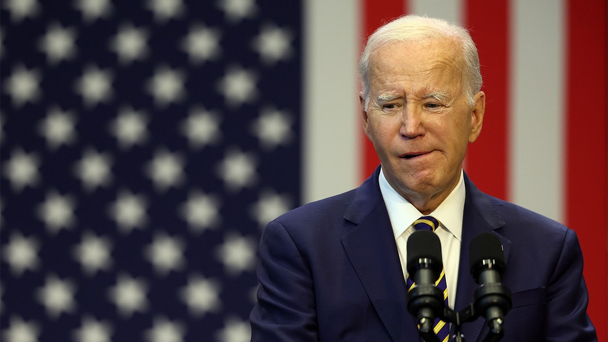 Joe Biden standing in front of an American flag