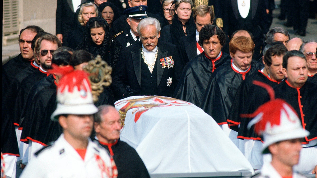 Funeral procession with a coffin draped in the Monaco flag