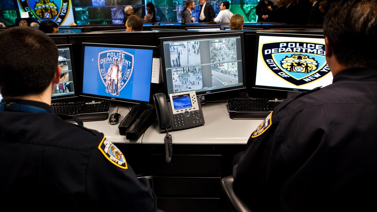 NYPD officers monitor live CCTV camera feeds from a command center